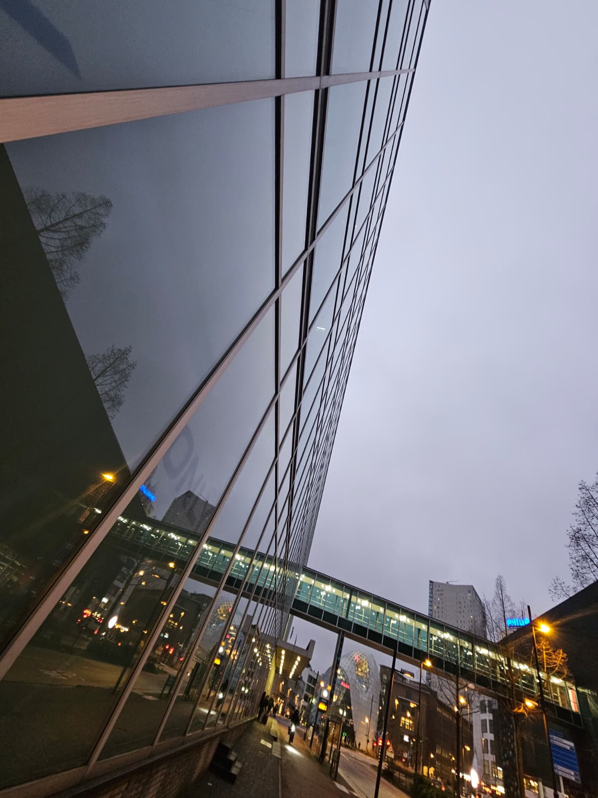 Glasgevel van een kantoorpand in Eindhoven in de schemer, streeploos schoongemaakt door Clean up support Nederland