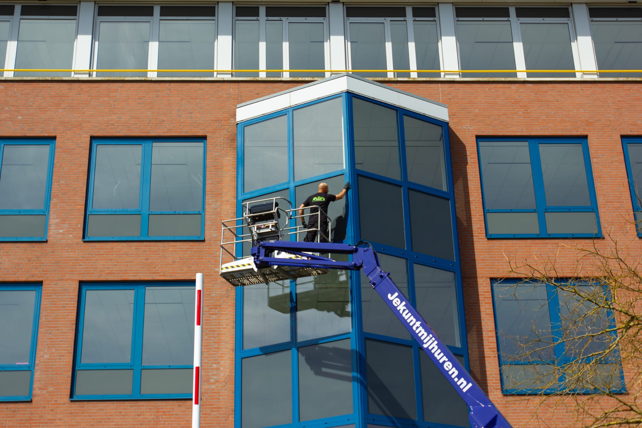 Glasbewassing van een kantoorpand vanuit een hoogwerker