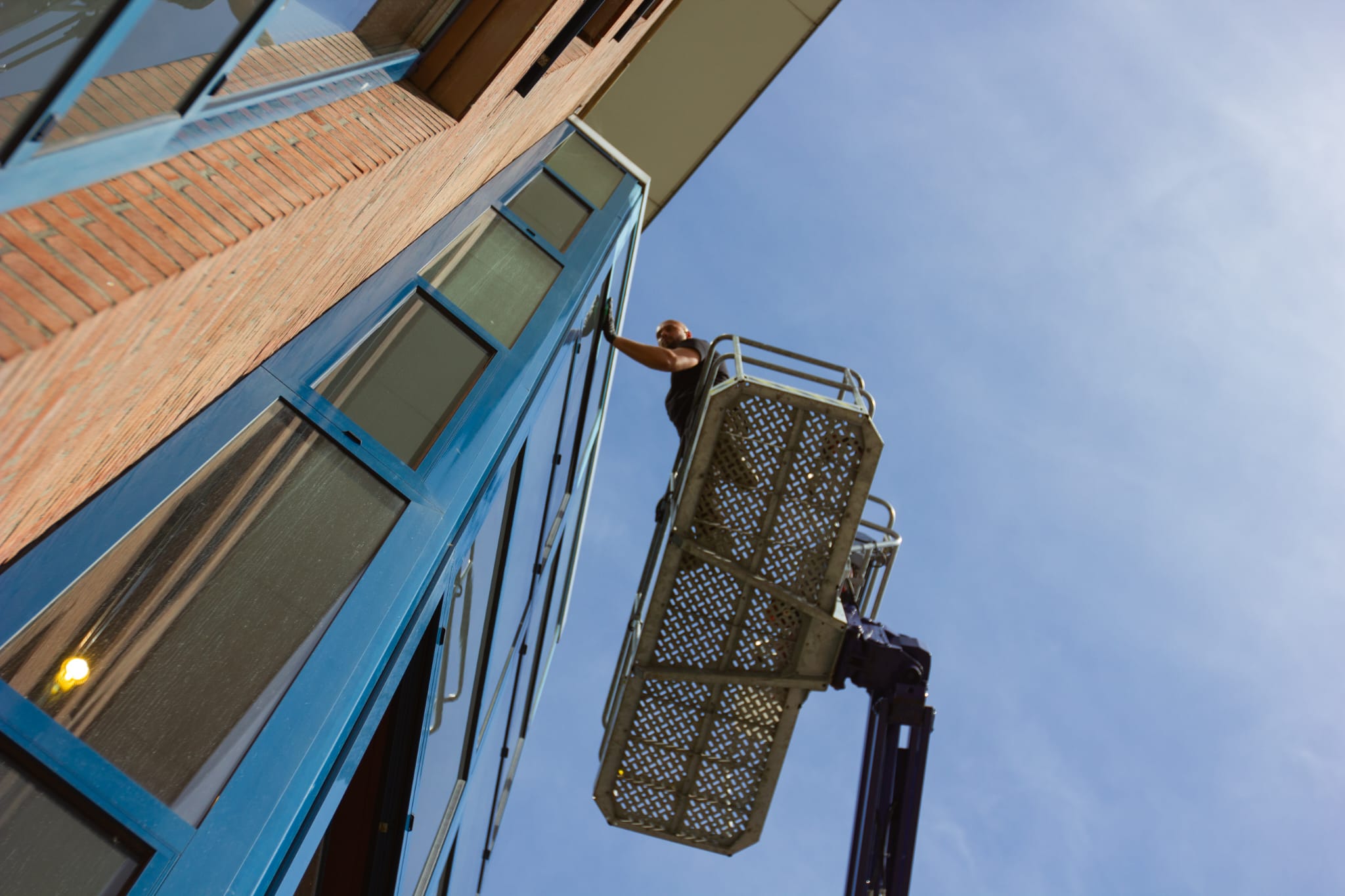 Glasbewasser van Clean up support Nederland aan het werk vanuit een hoogwerker
