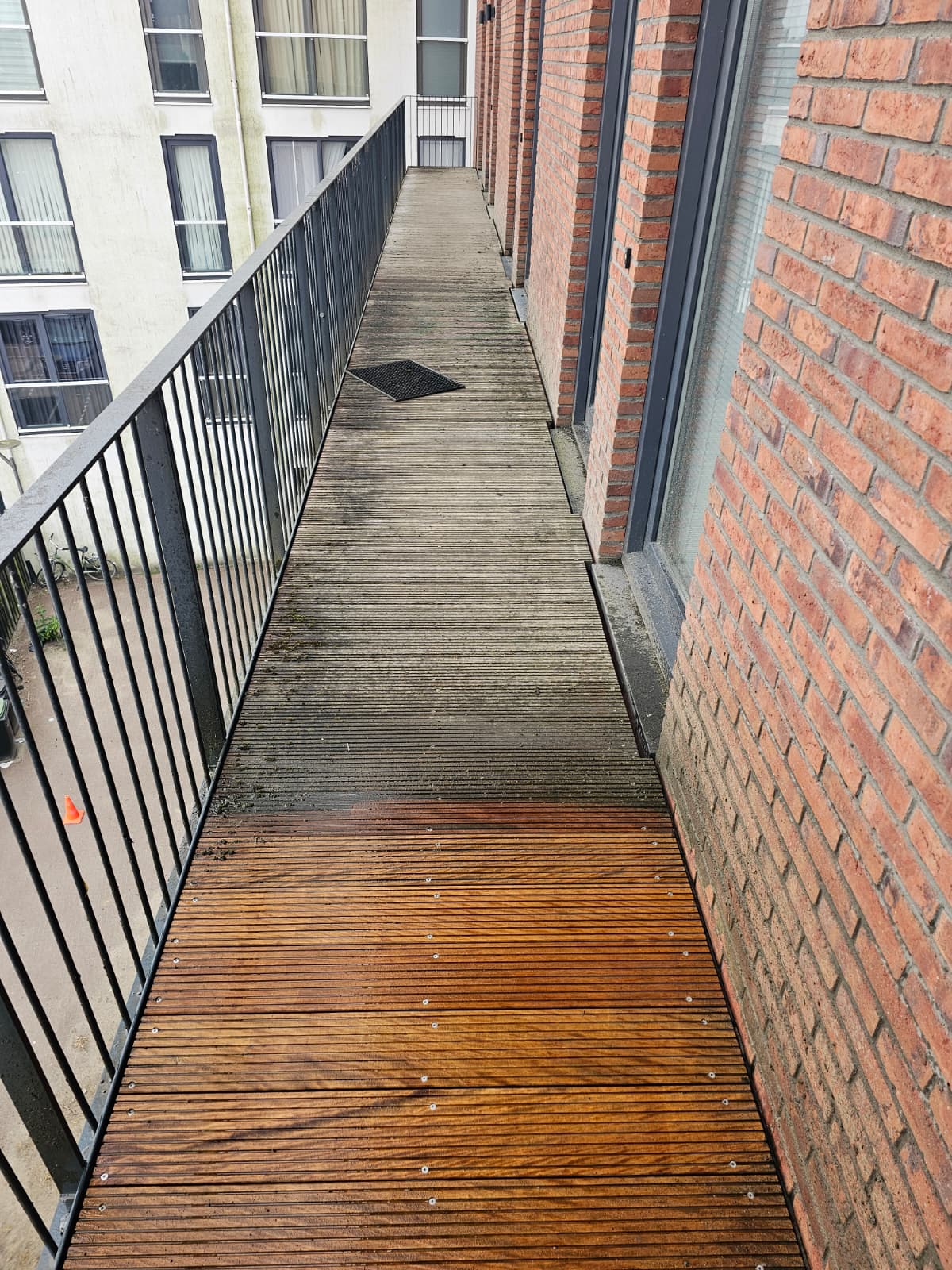 Houten galerijvlonder half gereinigd — links vuil en grijs, onder weer als nieuw